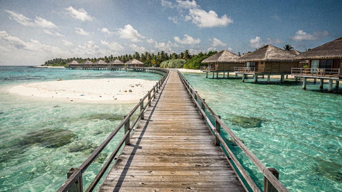 Overwater villas and a white sandbank at Sun Siyam Iru Fushi in Noonu Atoll, Maldives